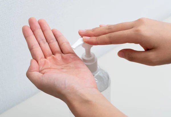 Women's hands using sanitizing gel