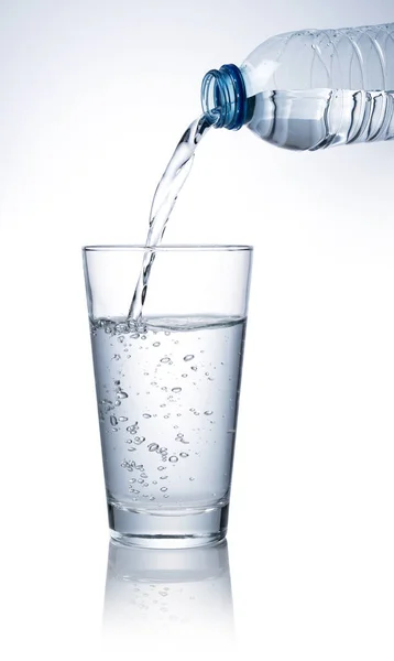 Giet Gebotteld Water Een Helder Glas Geplaatst Een Witte Achtergrond — Stockfoto