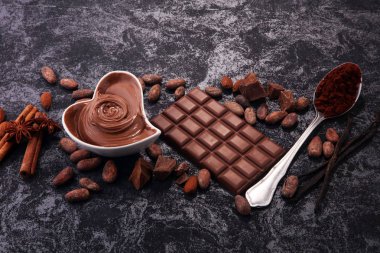 Çikolata çikolata tozu ile masada. Çikolatalı girdap ve fındık