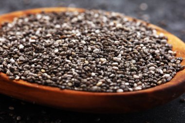 Masanın üzerindeki tahta kaşıkta sağlıklı Chia tohumları..
