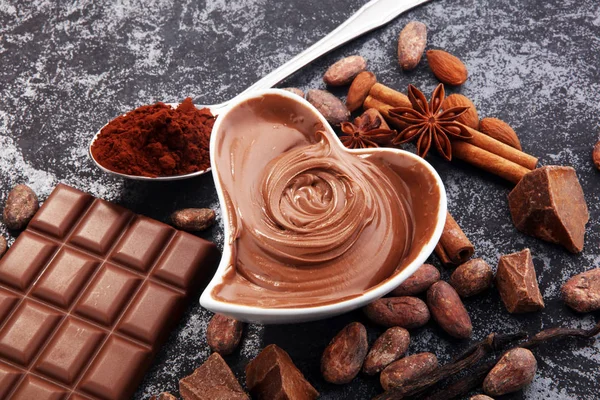 Çikolata çikolata tozu ile masada. Çikolatalı girdap ve fındık
