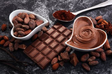 Çikolata çikolata tozu ile masada. Çikolatalı girdap ve fındık