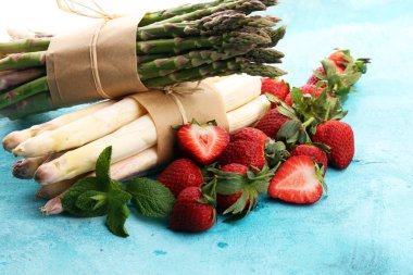 Beyaz ve yeşil taze kuşkonmaz sağlıklı çilek bir grup ile