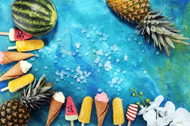 Yoğurt veya yumuşak kıvamlı dondurma waffle koni ve tropikal meyve ile renkli buzlu çubuk vanilya dondurulmuş