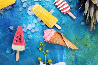 Yoğurt veya yumuşak kıvamlı dondurma waffle koni ve tropikal meyve ile renkli buzlu çubuk vanilya dondurulmuş