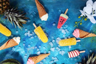 Yoğurt veya yumuşak kıvamlı dondurma waffle koni ve tropikal meyve ile renkli buzlu çubuk vanilya dondurulmuş