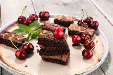 Ev yapımı çikolatalı kek ve kiraz rustik masada. Brownie fırın