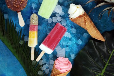 Yoğurt veya yumuşak kıvamlı dondurma waffle koni ve tropikal meyve ile renkli buzlu çubuk vanilya dondurulmuş