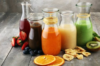 Sebze ve meyve ile rustik arka plan üzerinde renkli smoothies yelpazesi