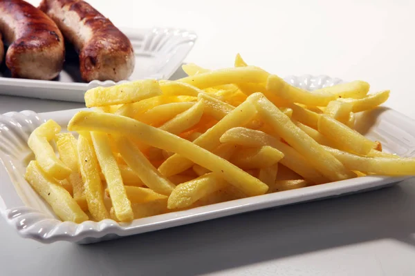 Grilled sausage served with french fries or fried potatoes with sausage.