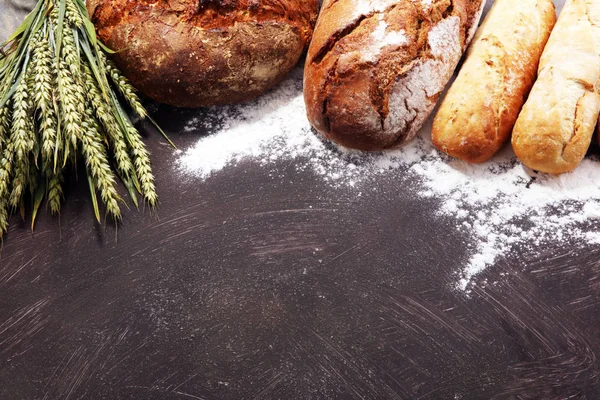 不同种类的面包和面包卷在船上从上面 厨房或烘焙海报设计 — 图库照片