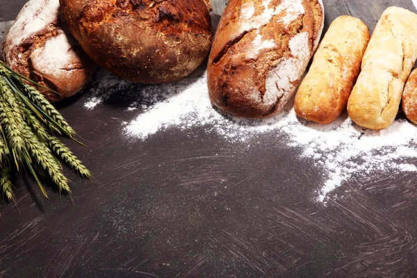 不同种类的面包和面包卷在船上从上面 厨房或烘焙海报设计 — 图库照片