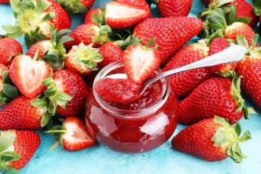 çilek reçeli taze çilek ile. kaşık ve kavanoz marmelat.