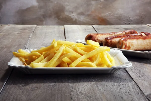 Grilled sausage served with french fries or fried potatoes with sausage.