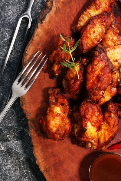 Barbekü tavuk kanadı ahşap tepsi üzerinde Kapat.