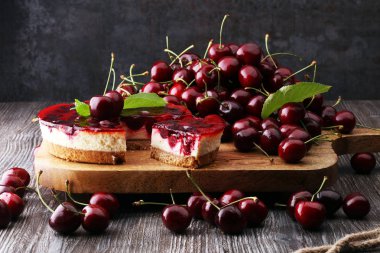 Vanilyalı ve ahşap masada siyah kirazlı ev yapımı vişneli pasta.