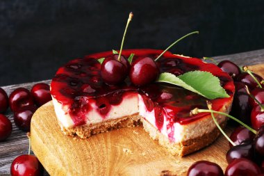Vanilyalı ve ahşap masada siyah kirazlı ev yapımı vişneli pasta.