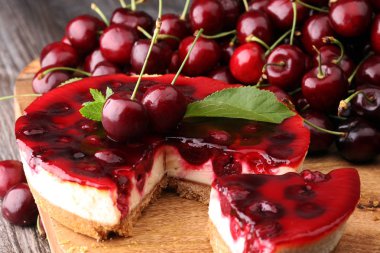 Vanilyalı ve ahşap masada siyah kirazlı ev yapımı vişneli pasta.