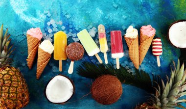 Yoğurt veya yumuşak kıvamlı dondurma waffle koni ve tropikal meyve ile renkli buzlu çubuk vanilya dondurulmuş
