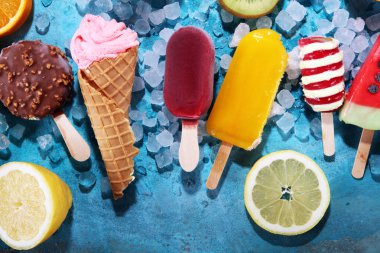 Yoğurt veya yumuşak kıvamlı dondurma waffle koni ve tropikal meyve ile renkli buzlu çubuk vanilya dondurulmuş