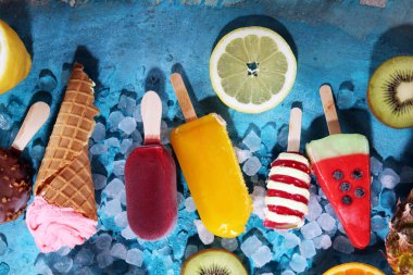 Yoğurt veya yumuşak kıvamlı dondurma waffle koni ve tropikal meyve ile renkli buzlu çubuk vanilya dondurulmuş