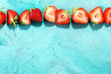 Yığın mavi zemin üzerine taze çilek.