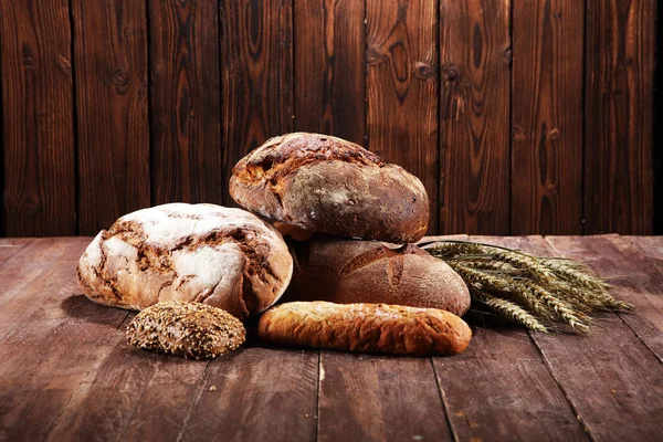 Different kinds of bread and bread rolls on board from above. Kitchen or bakery poster design.