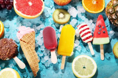 Yoğurt veya yumuşak kıvamlı dondurma waffle koni ve tropikal meyve ile renkli buzlu çubuk vanilya dondurulmuş