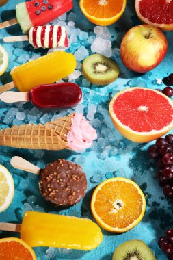 Yoğurt veya yumuşak kıvamlı dondurma waffle koni ve tropikal meyve ile renkli buzlu çubuk vanilya dondurulmuş