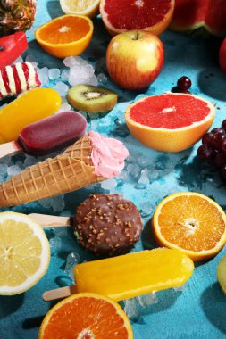 Yoğurt veya yumuşak kıvamlı dondurma waffle koni ve tropikal meyve ile renkli buzlu çubuk vanilya dondurulmuş