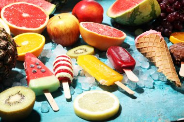 Yoğurt veya yumuşak kıvamlı dondurma waffle koni ve tropikal meyve ile renkli buzlu çubuk vanilya dondurulmuş