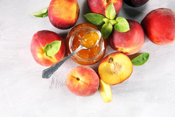 Peach vanilla jam with fresh peaches on table