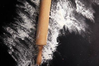 Arka plan ile oklava un ile kabartma. Karanlık masaya. Metin için özgür yer. Üstten Görünüm