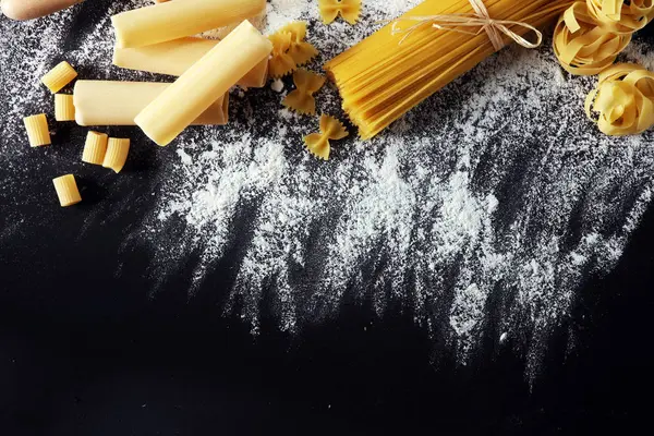 Makarna rustik arka plan üzerine çeşitli karışımı. Ev yapımı makarna yapma