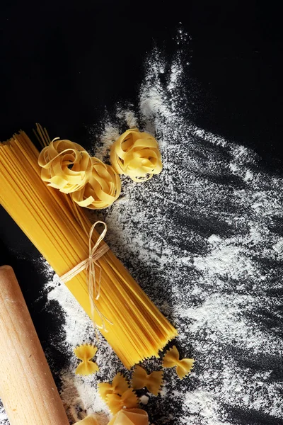 Makarna rustik arka plan üzerine çeşitli karışımı. Ev yapımı makarna yapma