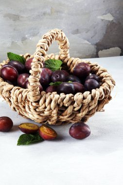 Erik rustik taş zemin üzerine. Mavi erik meyve yarısı. Yaprakları ile birçok güzel Erik.