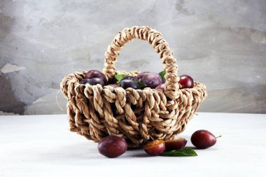 Erik rustik taş zemin üzerine. Mavi erik meyve yarısı. Yaprakları ile birçok güzel Erik.