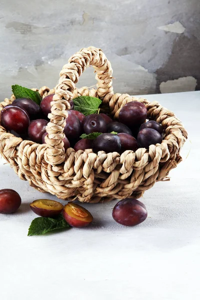 Erik rustik taş zemin üzerine. Mavi erik meyve yarısı. Yaprakları ile birçok güzel Erik.