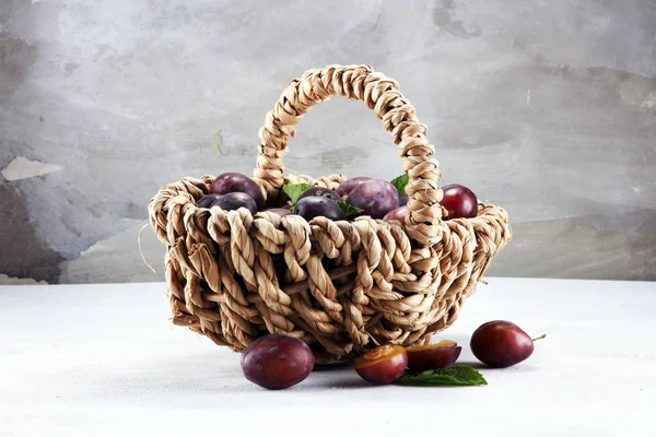 Erik rustik taş zemin üzerine. Mavi erik meyve yarısı. Yaprakları ile birçok güzel Erik.