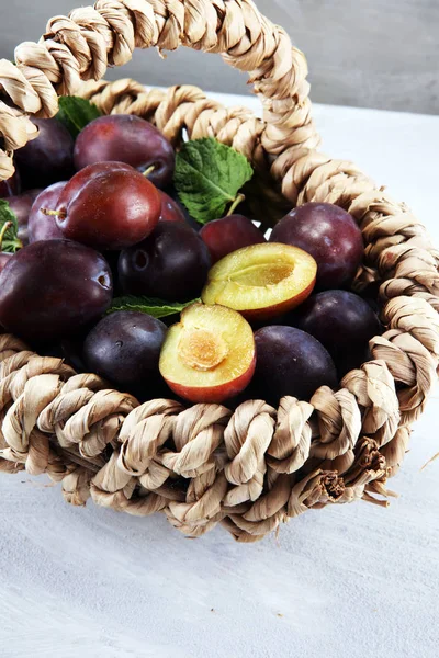 Erik rustik taş zemin üzerine. Mavi erik meyve yarısı. Yaprakları ile birçok güzel Erik.