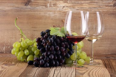 Kırmızı şarap ve beyaz şarap üzüm ve rustik zemin üzerine gözlük ile