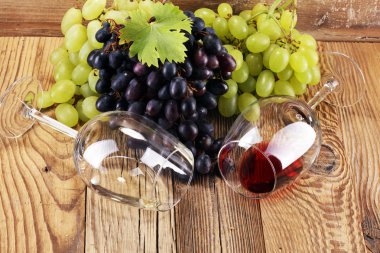 Kırmızı şarap ve beyaz şarap üzüm ve rustik zemin üzerine gözlük ile