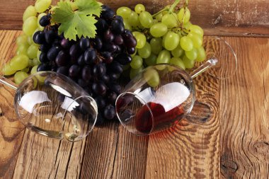 Kırmızı şarap ve beyaz şarap üzüm ve rustik zemin üzerine gözlük ile