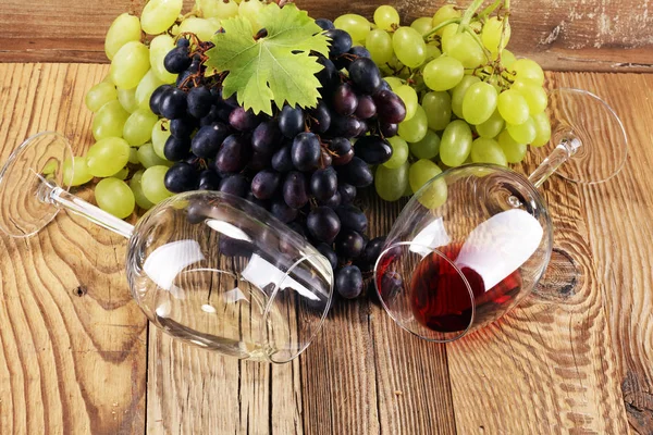 Kırmızı şarap ve beyaz şarap üzüm ve rustik zemin üzerine gözlük ile