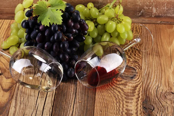 Kırmızı şarap ve beyaz şarap üzüm ve rustik zemin üzerine gözlük ile