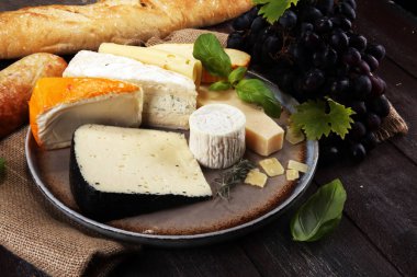 Rustik plaka üzerinde farklı peynir peynir tabağı.