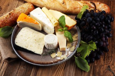 Rustik plaka üzerinde farklı peynir peynir tabağı.