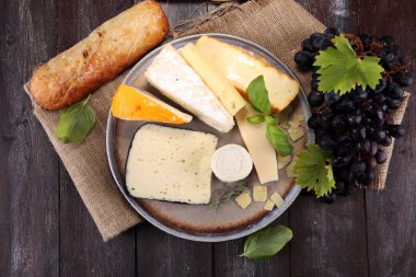 Rustik plaka üzerinde farklı peynir peynir tabağı.