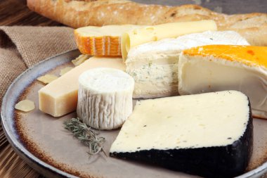 Rustik plaka üzerinde farklı peynir peynir tabağı.