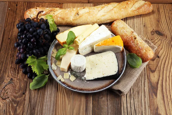 Rustik plaka üzerinde farklı peynir peynir tabağı.